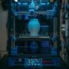 Close-up of a 3D printer in action, crafting a detailed vase in a modern setting.